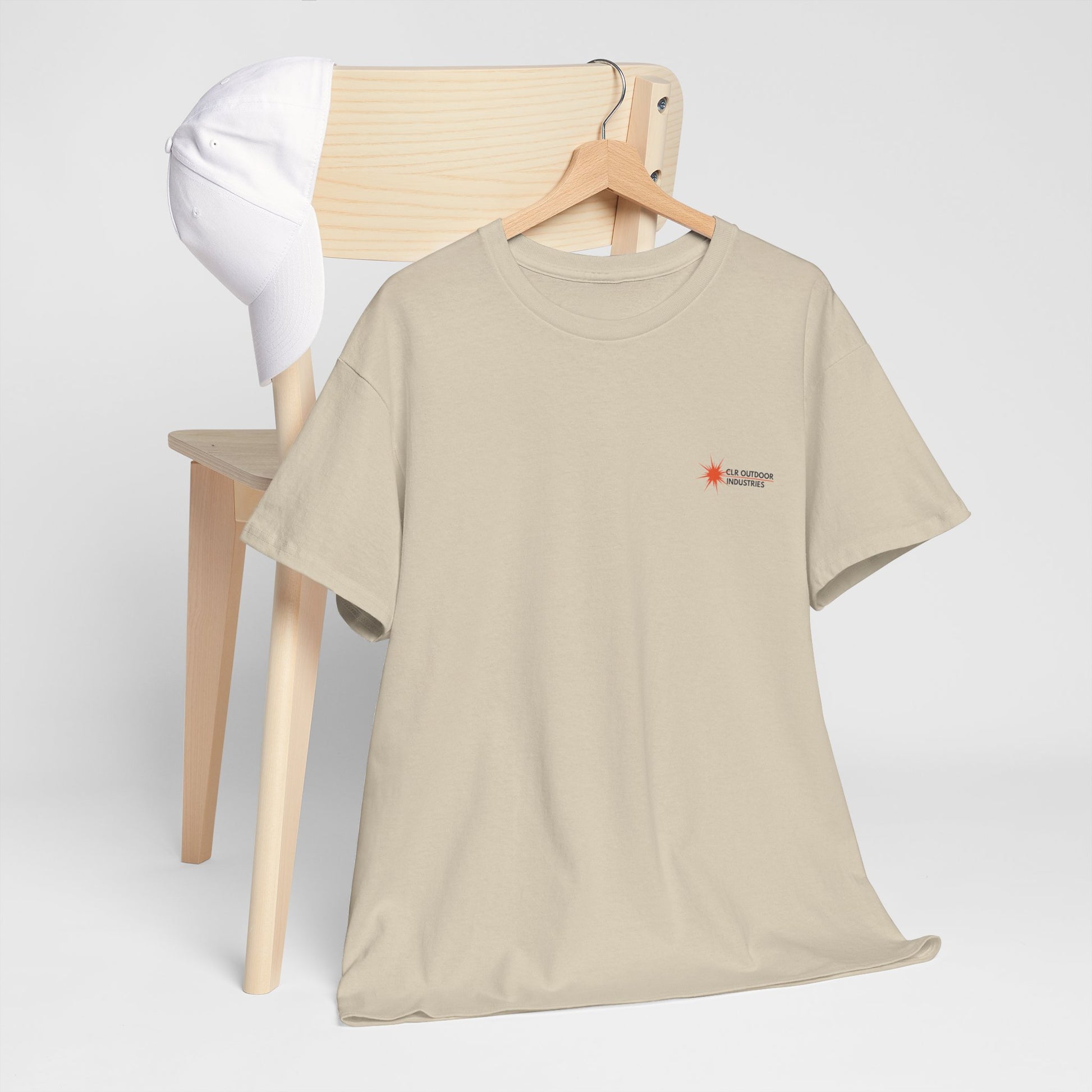 „Sandfarbenes NEW WAVE CLR Outdoor Industrie T-Shirt von CLR Outdoor GmbH mit kleinem roten Stern-Kompass-Logo und Schriftzug CLR Outdoor Industries auf der linken Brust.hängend mit Kleiderbügel am Stuhl präsentiert."